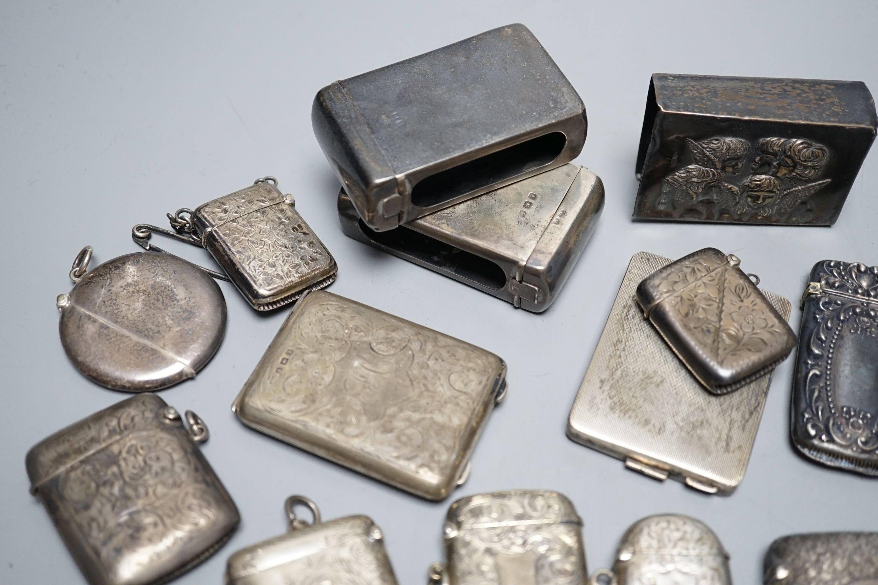 A collection of twenty six assorted mainly early 20th century silver or white metal vesta cases, including heart shape and combination vesta and cheroot cutter, largest 61mm and and seven assorted match cases or sleeves.